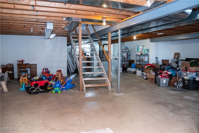 unfinished basement featuring washer / clothes dryer and stairs