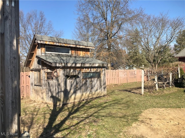 view of yard with an outbuilding, a storage shed, and a fenced backyard