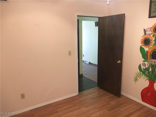 unfurnished room with wood finished floors and baseboards