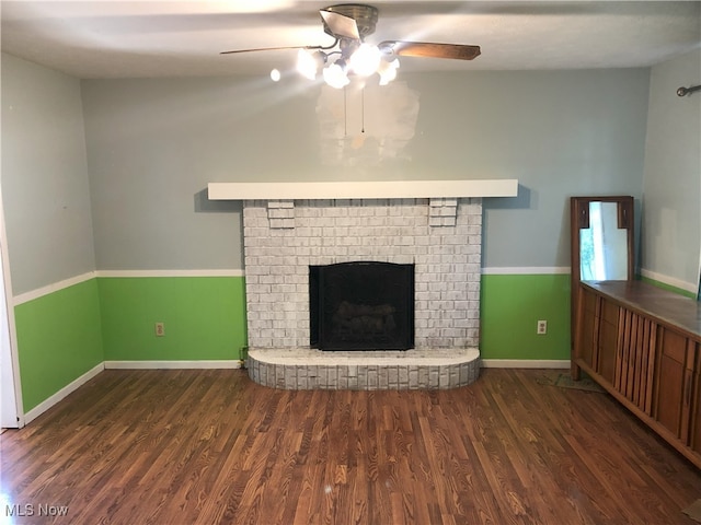 unfurnished living room featuring baseboards, wood finished floors, ceiling fan, and a fireplace