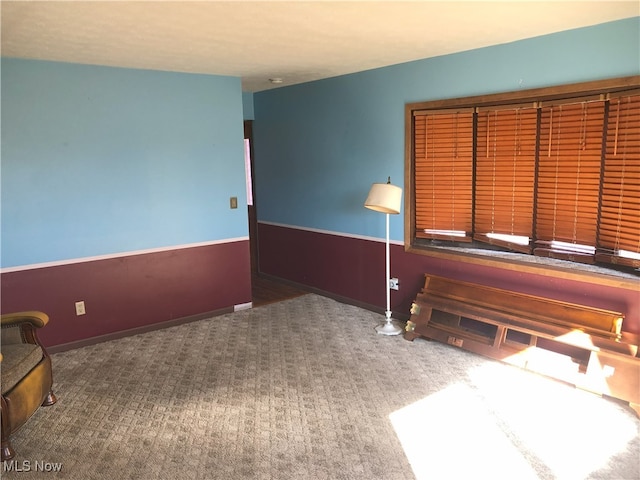 unfurnished room featuring a wainscoted wall