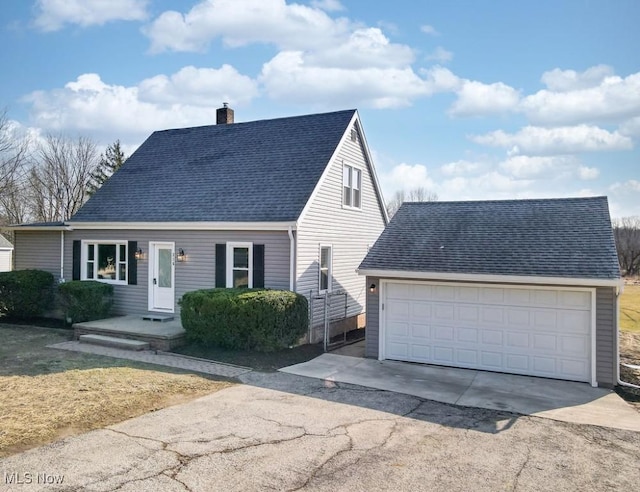 cape cod house with driveway, a garage, roof with shingles, and a chimney