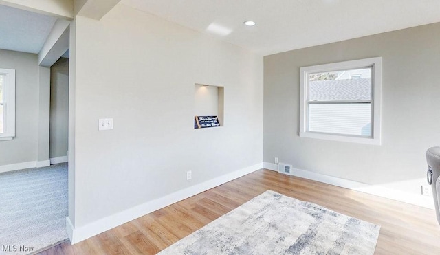 spare room featuring visible vents, baseboards, and wood finished floors