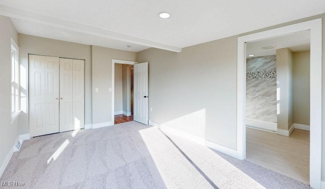 unfurnished bedroom with a closet, visible vents, carpet, and baseboards