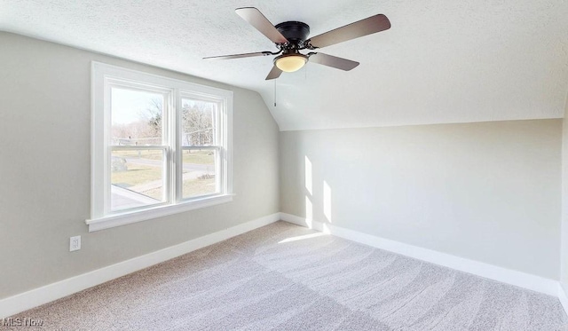 bonus room featuring a ceiling fan, baseboards, vaulted ceiling, a textured ceiling, and carpet flooring