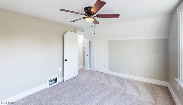 unfurnished bedroom with vaulted ceiling, baseboards, visible vents, and carpet floors