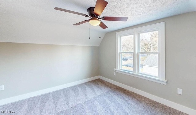 bonus room with a textured ceiling, carpet floors, baseboards, ceiling fan, and vaulted ceiling