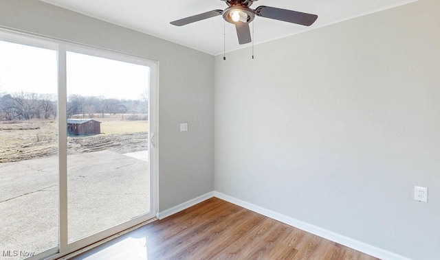 unfurnished room with wood finished floors, baseboards, and ceiling fan