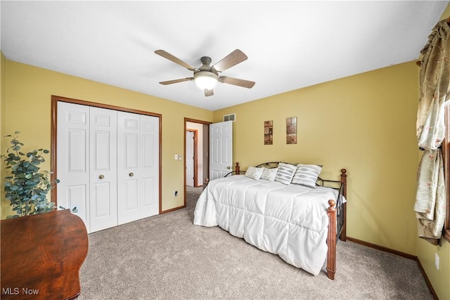 carpeted bedroom featuring a closet, baseboards, visible vents, and ceiling fan