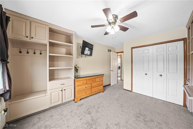 unfurnished bedroom with visible vents, washer / dryer, ceiling fan, a closet, and light colored carpet