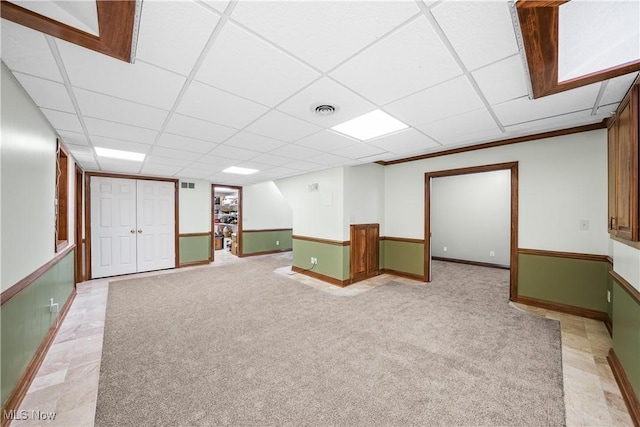 finished basement with a drop ceiling, visible vents, and light colored carpet