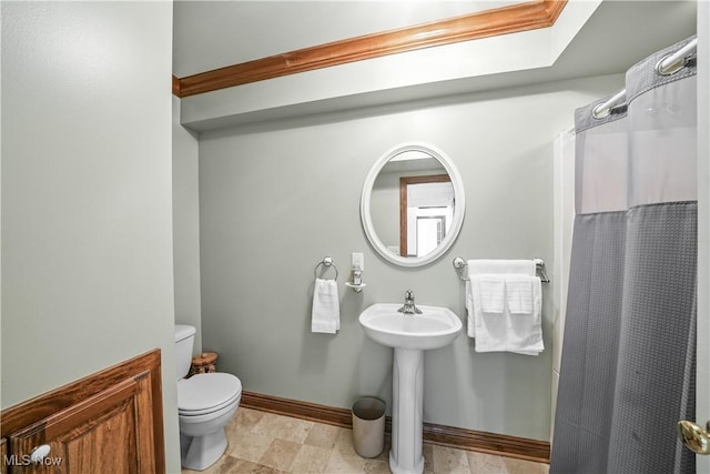 full bathroom with curtained shower, toilet, and baseboards