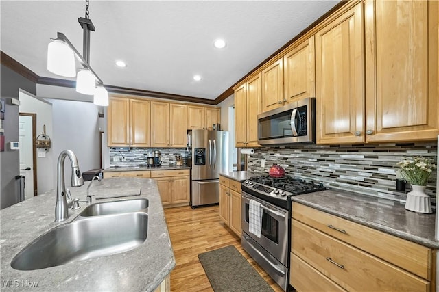 kitchen with a sink, crown molding, light brown cabinets, and stainless steel appliances