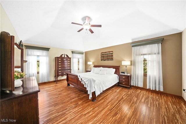 bedroom featuring ceiling fan, baseboards, lofted ceiling, and wood finished floors