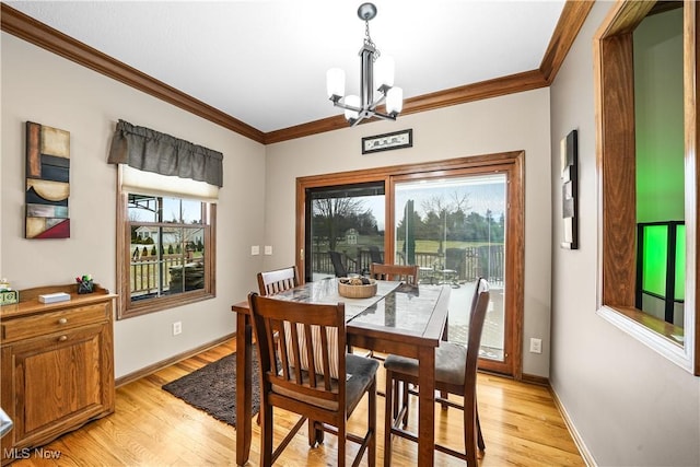 dining area with a notable chandelier, light wood-style flooring, and crown molding