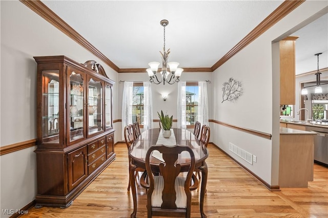 dining room featuring visible vents, an inviting chandelier, light wood-style flooring, and ornamental molding