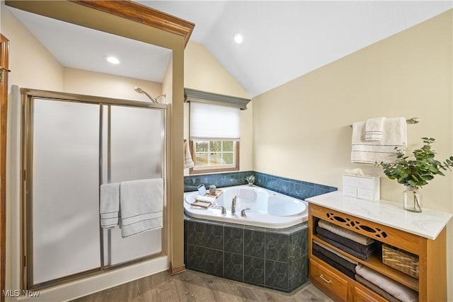 bathroom featuring lofted ceiling, a garden tub, wood finished floors, and a shower stall