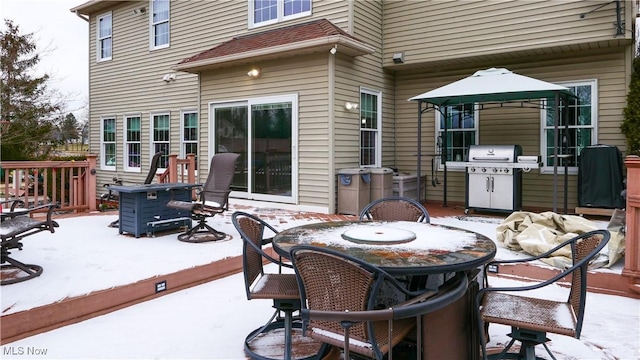 deck with grilling area, outdoor dining area, and a patio