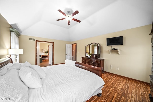 bedroom featuring a ceiling fan, wood finished floors, visible vents, baseboards, and vaulted ceiling