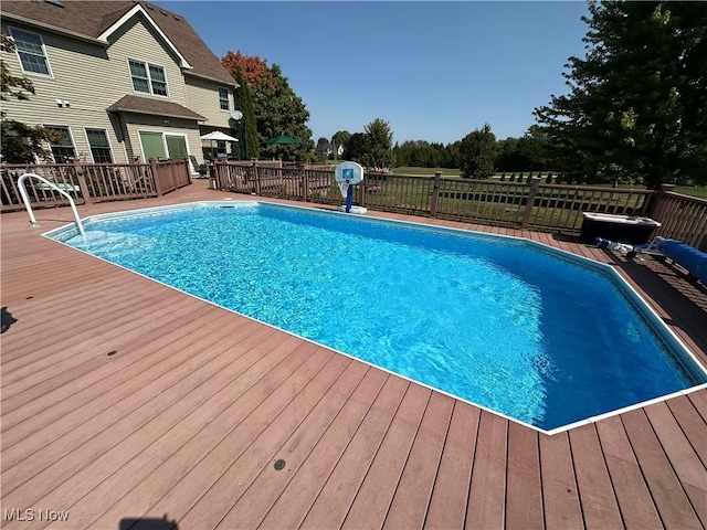 view of swimming pool with a fenced in pool and a wooden deck