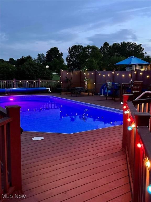 view of swimming pool featuring a deck and a fenced in pool