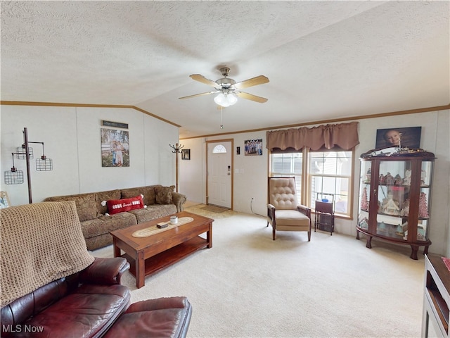 carpeted living room featuring a textured ceiling, lofted ceiling, a ceiling fan, and ornamental molding