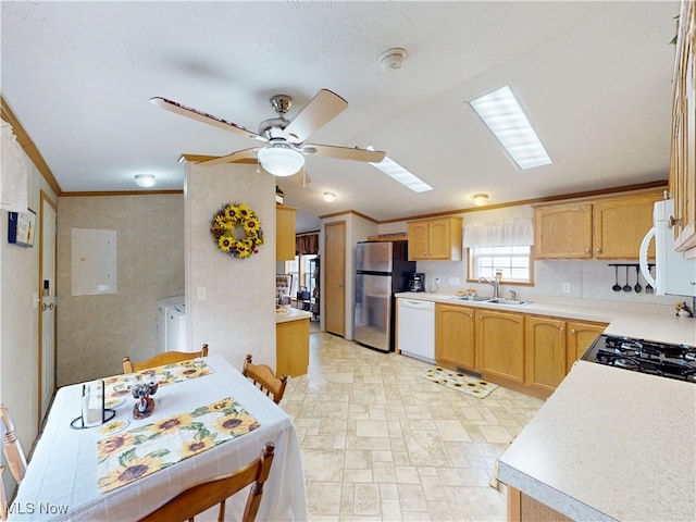 kitchen with a sink, electric panel, freestanding refrigerator, separate washer and dryer, and white dishwasher