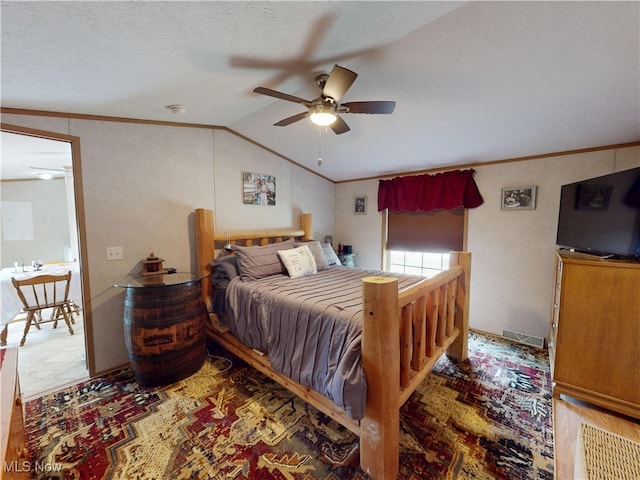 bedroom featuring visible vents, lofted ceiling, a ceiling fan, and crown molding