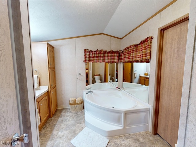 full bath with a garden tub, toilet, ornamental molding, vanity, and vaulted ceiling