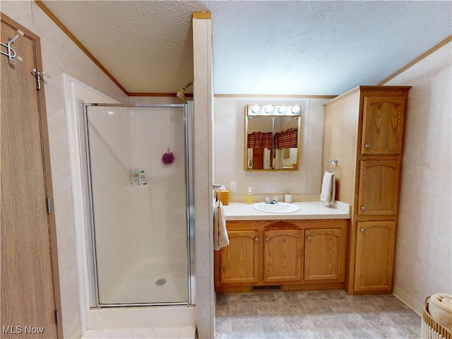 full bath with vanity, a shower stall, visible vents, and a textured ceiling