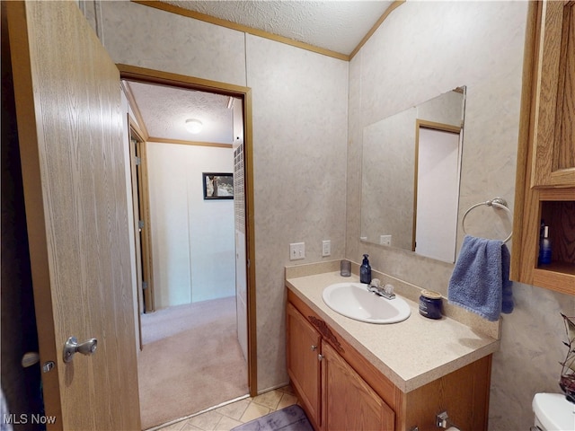 bathroom with a textured ceiling, crown molding, vanity, and toilet