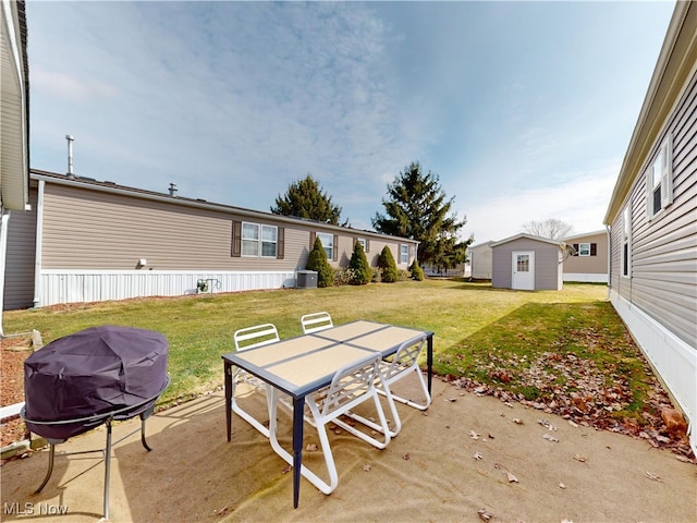 view of patio / terrace with an outbuilding, a shed, grilling area, outdoor dining area, and central AC unit