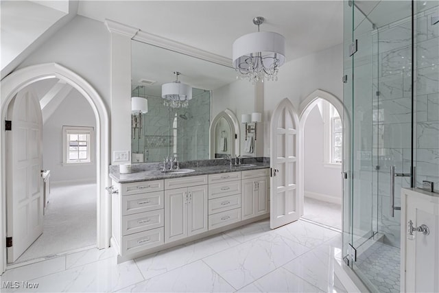 full bathroom with marble finish floor, a stall shower, and a sink