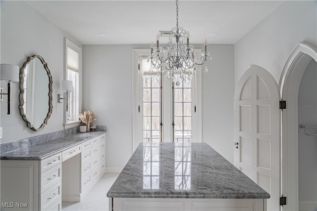 dining space with french doors, arched walkways, and a notable chandelier