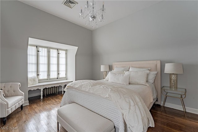 bedroom featuring a chandelier, visible vents, baseboards, and wood-type flooring