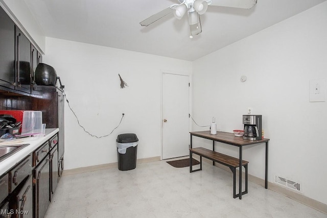 interior space with visible vents, baseboards, ceiling fan, light floors, and a sink