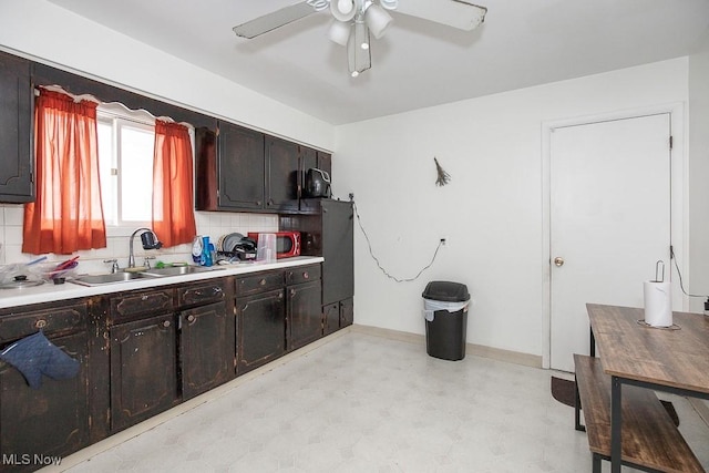 kitchen with light floors, light countertops, ceiling fan, and a sink