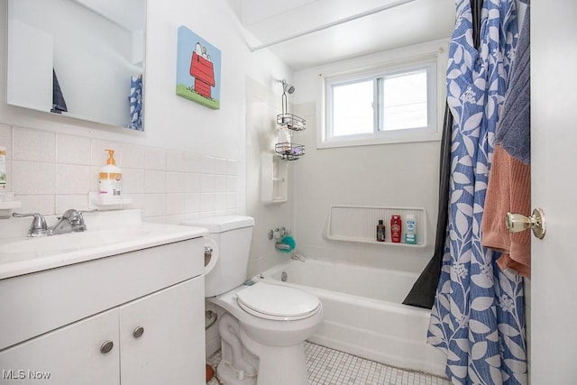 full bath featuring tile patterned floors, shower / bath combo with shower curtain, toilet, tile walls, and vanity