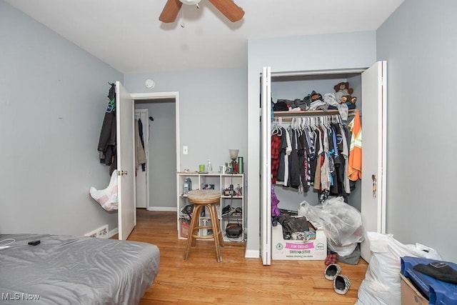 bedroom with light wood-type flooring, baseboards, a closet, and ceiling fan