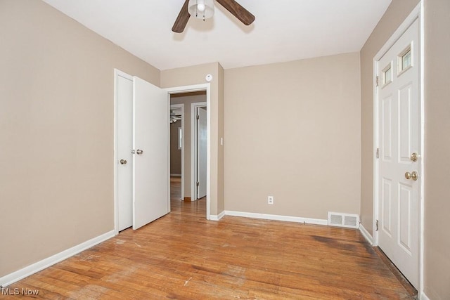 unfurnished bedroom with visible vents, baseboards, a ceiling fan, and light wood finished floors