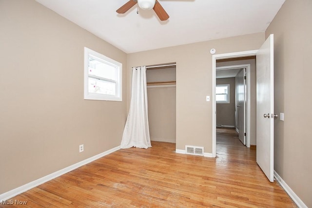 unfurnished bedroom with visible vents, baseboards, a closet, and light wood-style flooring