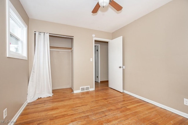 unfurnished bedroom with baseboards, visible vents, a closet, and light wood-type flooring