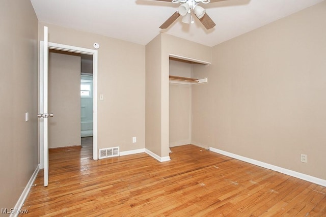 unfurnished bedroom with light wood-style flooring, baseboards, visible vents, and a closet