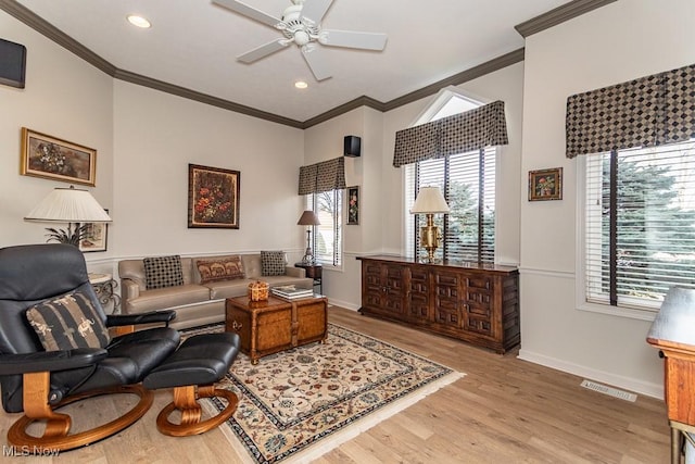 living area featuring crown molding, a ceiling fan, and light wood-style floors