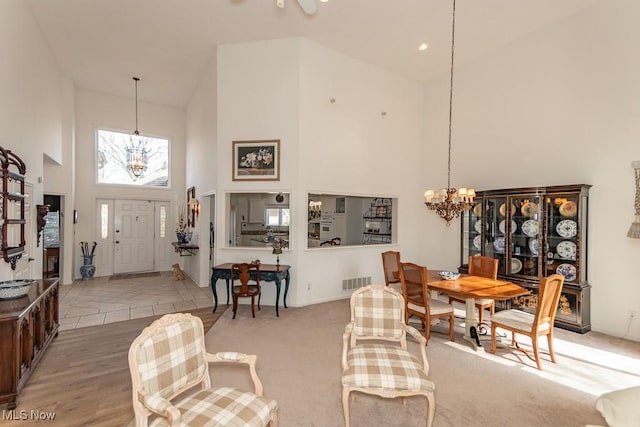 interior space featuring an inviting chandelier, visible vents, and high vaulted ceiling