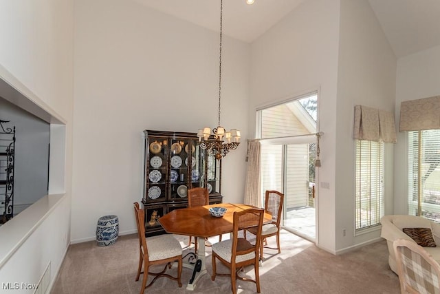 dining room with visible vents, light colored carpet, an inviting chandelier, and high vaulted ceiling