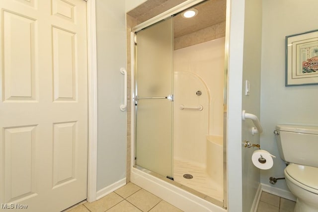 full bath featuring tile patterned flooring, a stall shower, and toilet