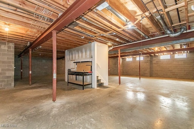 below grade area featuring stairs and concrete block wall