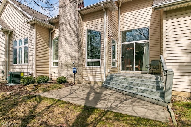 back of property featuring a patio area, central AC unit, and a chimney