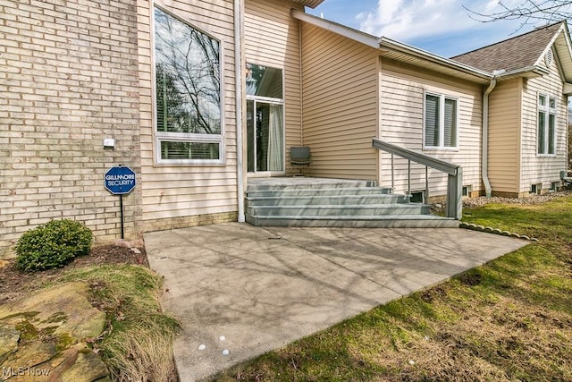 view of exterior entry with a patio area